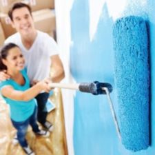 husband and wife painting a wall