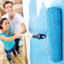 husband and wife painting a wall