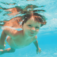 kid swimming under water in pool