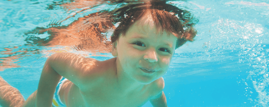 kid swimming under water in pool