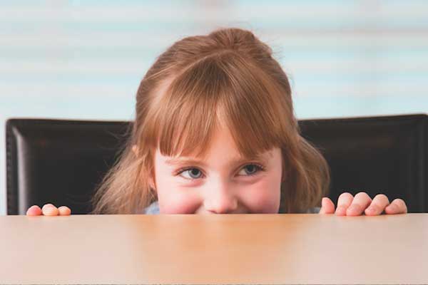 girl peeking over table