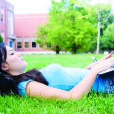 female college student on laptop outdoors