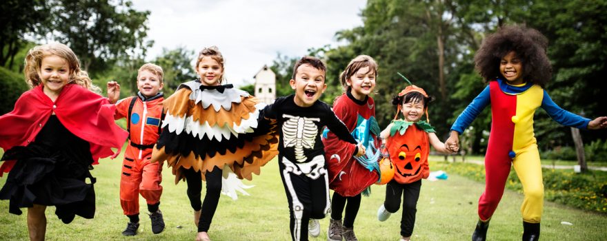 kids in halloween costumes running in a field