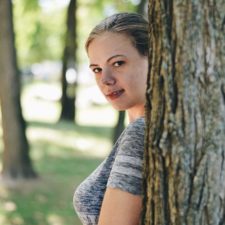 girl behind tree