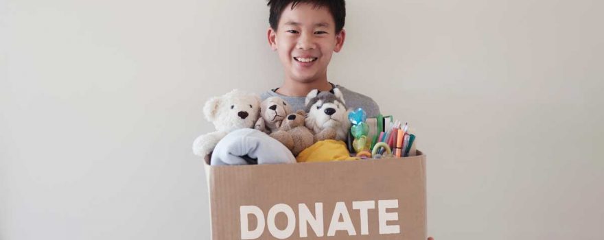 child holding box of donations for charity