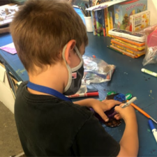 boy in face mask doing crafts