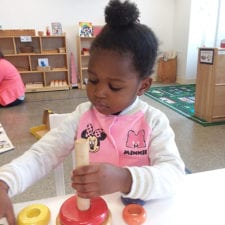 toddler girl playing with wooden rings