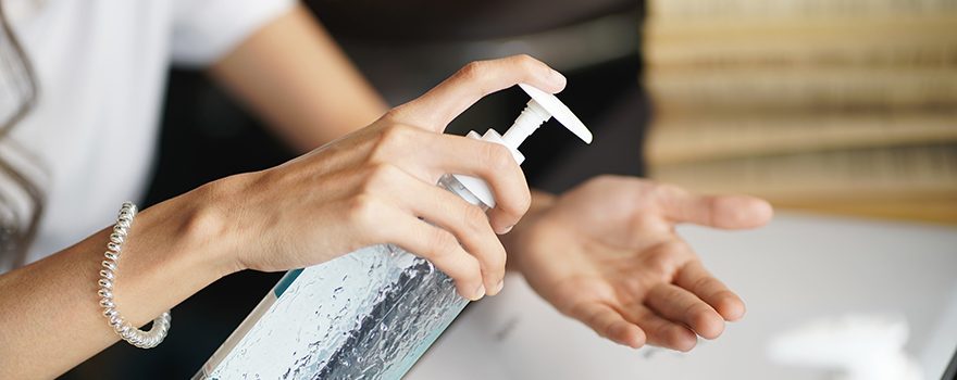 woman using hand sanitizer