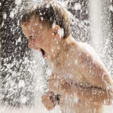 kid playing in sprinkler