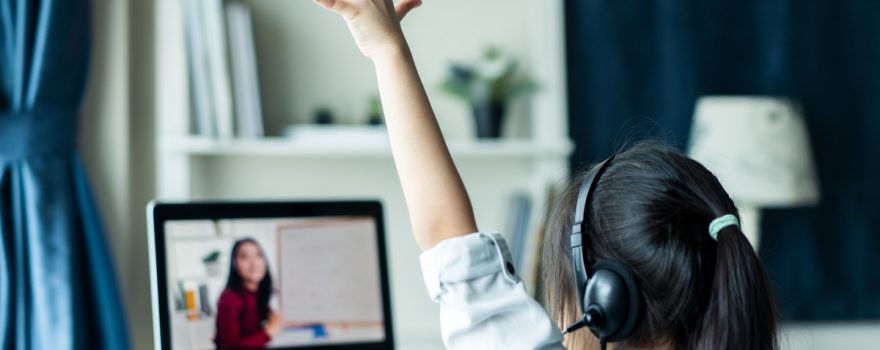 Girl raising hand during remote learning