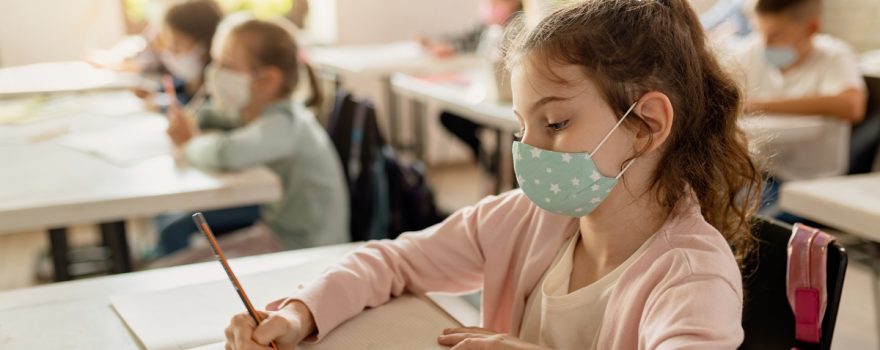 School girl takes test with Covid mask on