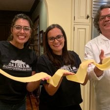 Italian cooks hold up homemade pasta for cooking show.