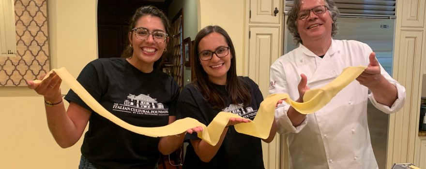 Italian cooks hold up homemade pasta for cooking show.