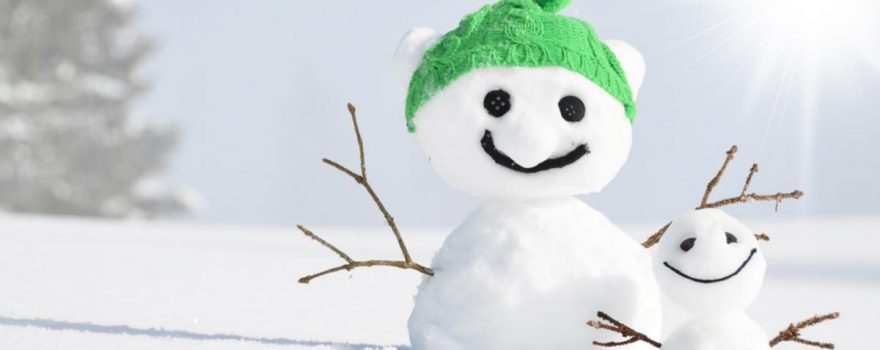 Big snowman in green hat next to little snowman