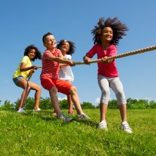 Kids playing tug-of-war in grass