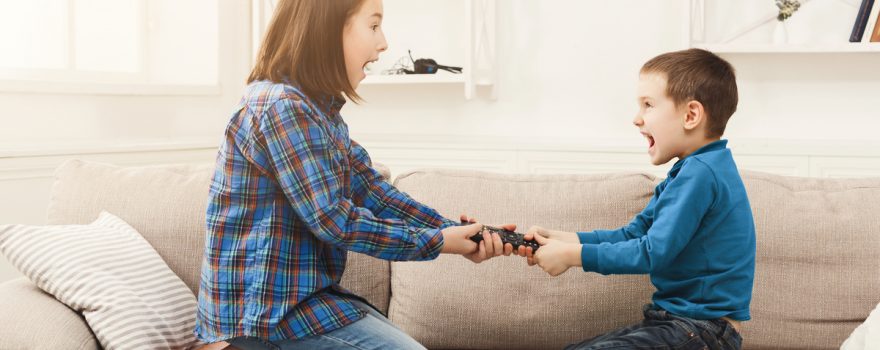 Boy and girl fighting over remote