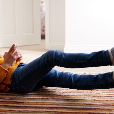 kid on floor looking at phone