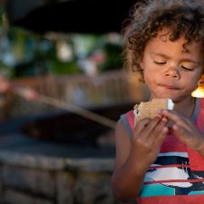 boy eating s'mores and camping