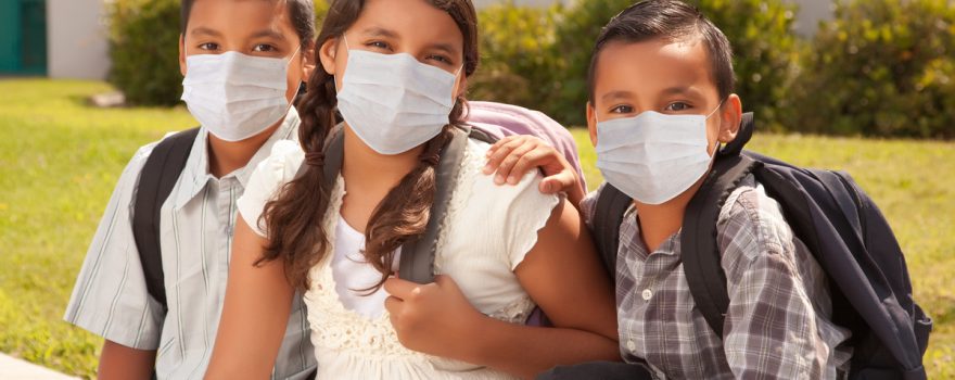 kids in schoolbags wearing masks