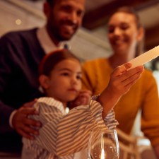 Jewish family lights a menorah during Hanukkah