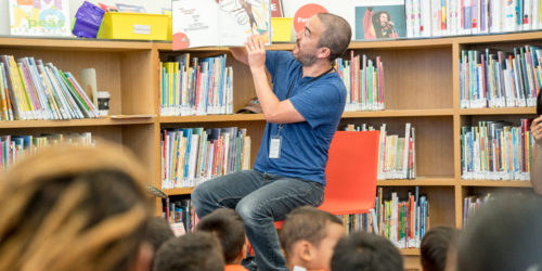 man reading a story to kids