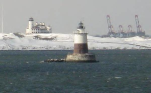 lighthouse in the water on a cold day with snow around
