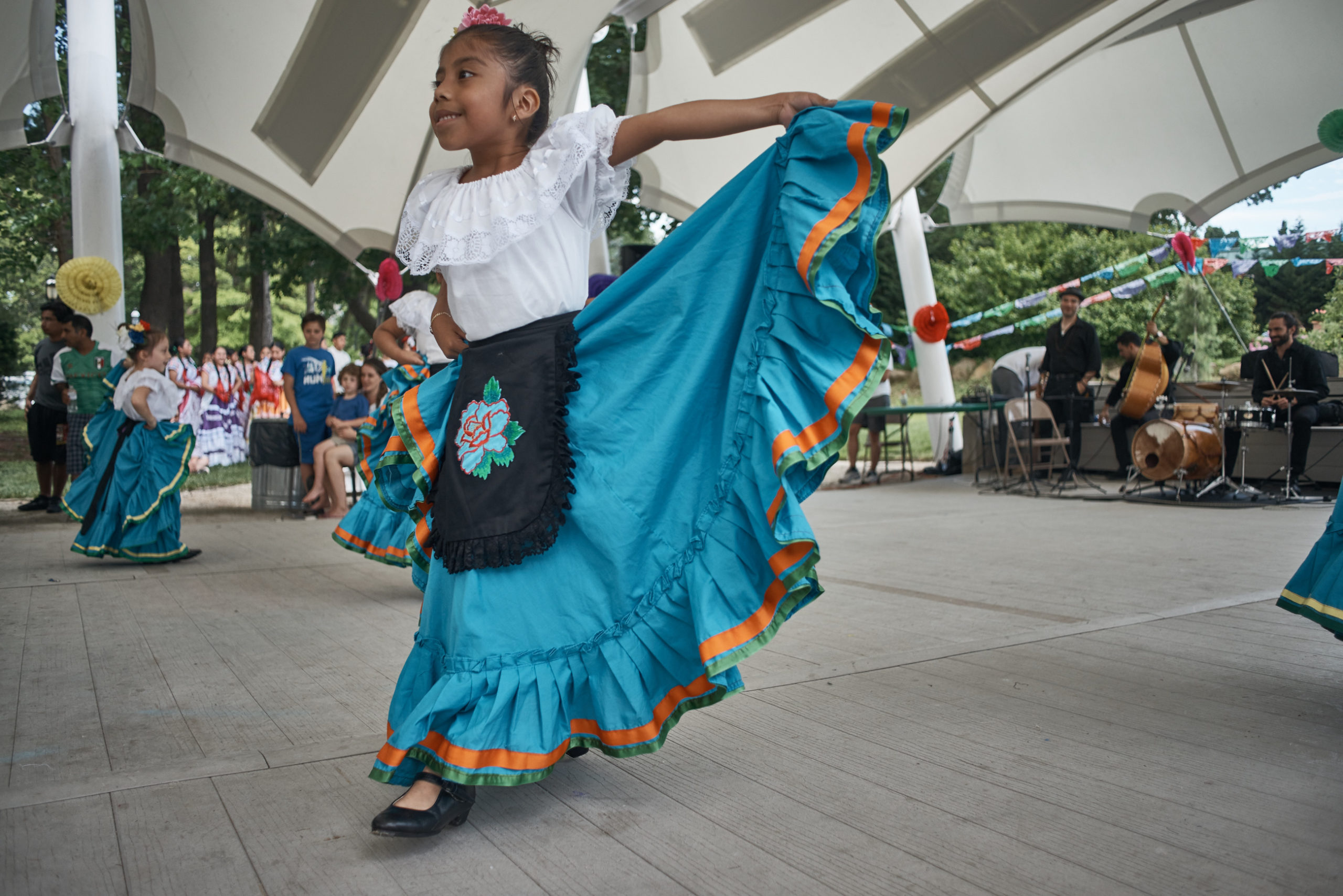 young girl dancing in traditional Mexican clothing