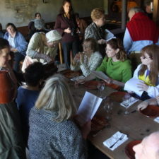 people at a table interacting with others in colonial costume at Historic Richmond Town
