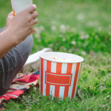 person sitting on lawn eating popcorn