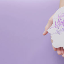 Hands holding encephalography brain paper cutout