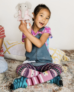 Little girl with elephant doll, which is a screen-free gift.