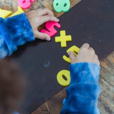 Toddler playing with toy numbers in preschool.