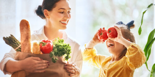 Mother and daughter holding groceries.