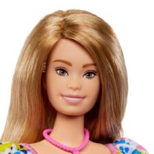 Barbie doll with Down syndrome. She's wearing a floral dress with puffy sleeves.