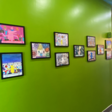 Colorful artwork hanging on a wall by Michael J. Petrides School students.
