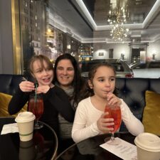 A mom who is nominated in a Super Mom contest sitting in a restaurant with her two daughters.