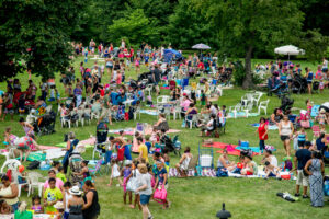 families on a sprawling lawn at Sprinklerfest at Snug Harbor