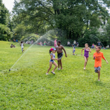 Children playing outside at Sprinklerfest at Snug Harbor