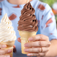 a vanilla soft serve ice cream cone and a chocolate soft serve ice cream cone from Carvel, which is offering deals for National Soft Serve Day.
