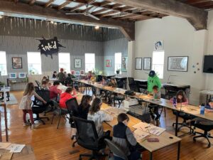children sitting at desks making art projects in an art studio owned by Clark Ruggeri, who knows how to make slime