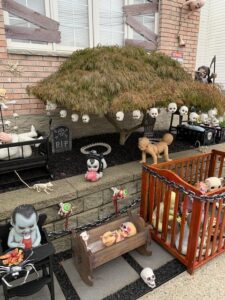 the yard of a house, which is one of several haunted houses on Staten Island decorated for Halloween, with artificial scary characters and Halloween accents