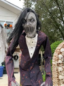 the yard of a house, which is one of several haunted houses on Staten Island decorated for Halloween, with artificial scary characters and Halloween accents