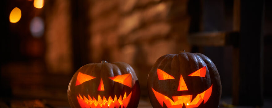 Two glowing jack-o’-lantern pumpkins at the entrance to a house, similar to decorations that can be part of haunted houses on Staten Island