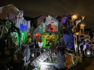 the yard of a house, which is one of several haunted houses on Staten Island decorated for Halloween, with artificial scary characters and Halloween accents