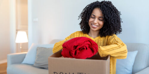 woman packing clothes into a box. Picture is for an article on where to donate clothes on Staten Island