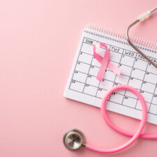 pink ribbon that raises awareness about breast cancer, with calendar and stethoscope, which highlights the importance of prioritizing breast health