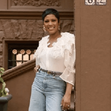 Tamron Hall leans on a post in front of her Harlem brownstone, son Moses in foreground.