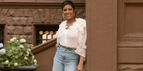 Tamron Hall leans on a post in front of her Harlem brownstone, son Moses in foreground.